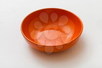 one orange bowl on white plastering plate