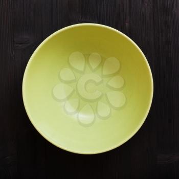 above view of one green bowl on dark brown table
