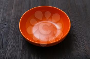 one orange bowl on dark brown board