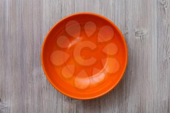 above view of one orange bowl on gray brown table