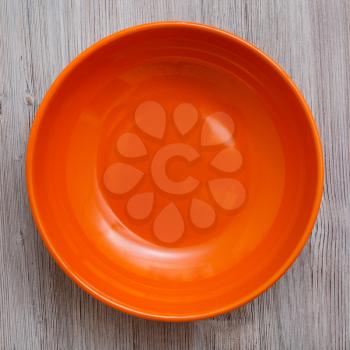 top view of one orange bowl on gray brown table