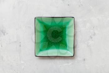 above view of green square saucer on gray concrete board