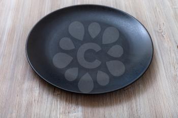 one black plate on gray brown table