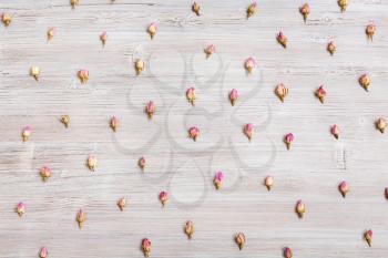 many natural pink rose flower buds on wooden board