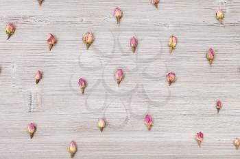 many natural pink rose flower buds close up on wooden board