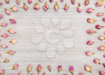 frame from natural pink rose flower buds on wooden table