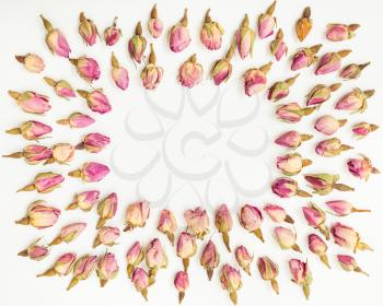 frame from many natural pink rose flowers on white textured paper background