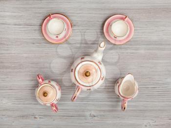 food concept - above view of pink porcelain tea set on gray brown table