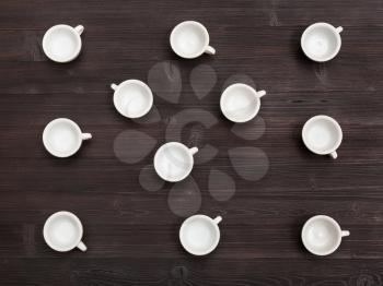 food concept - top view of lot of white cups on dark brown board