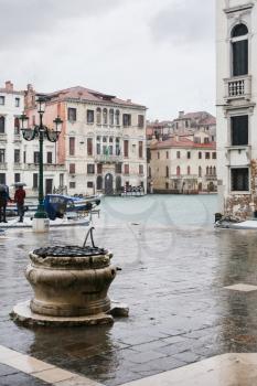 tourists wait water bus on square in Venice in rainy autumn day