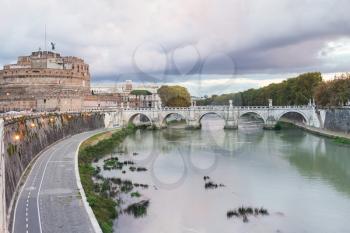 travel to Italy - waterfront of Tiber River, Castel Sant Angelo (Castle of the Holy Angel, Mausoleum of Hadrian) and bridge of St Angel in Rome city in autumn evening twilight