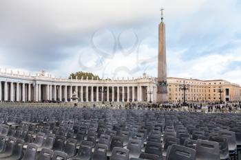 travel to Italy - Saint Peter's Square (Piazza San Pietro) with chairs and obelisk in Vatican city in evening