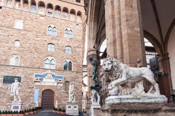 Medici Lion and Perseus statues in Loggia dei Lanzi and Palazzo Vecchio (Town Hall) on Piazza della Signoria in Florence city in morning.