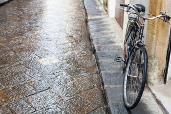 travel to Italy - bicycle on wet street in Florence city in autumn rain