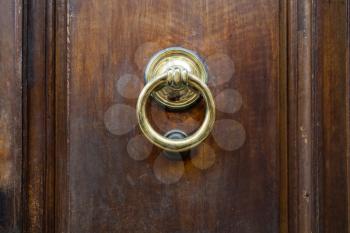 travel to Italy - brass ring knocker on old wooden door in Florence city