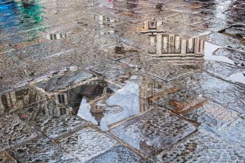 travel to Italy - rain puddle on pavement on piazza san giovanni near Florence Baptistery in rain