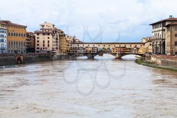 travel to Italy - brown water of Arno river and view of Ponte Vecchio (Old Bridge) in Florence city in autumn