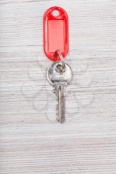 door key with red blank keychain on wood table