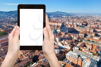 travel concept - tourist photographs Bologna city on tablet with cut out screen with blank place for advertising in Italy