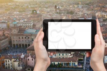 travel concept - tourist photographs main square in Bologna city on tablet with cut out screen with blank place for advertising in Italy