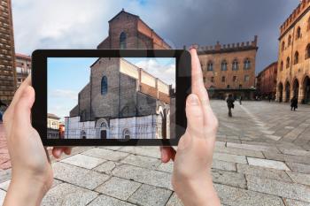 travel concept - tourist photographs basilica San Petronio in Bologna city on tablet in Italy