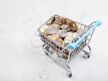 shopping trolley with russian coins on concrete plate