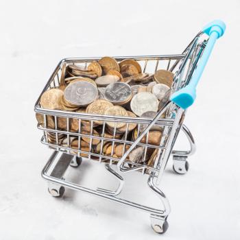 shopping cart with russian coins on concrete plate