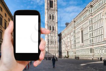 travel concept - tourist photographs Duomo and campanile in Florence city on smartphone with cut out screen with blank place for advertising in Italy