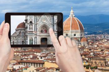 travel concept - tourist photographs walls of Duomo Santa Maria del Fiore in Florence city on tablet in Italy