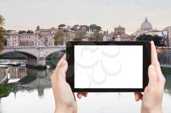 travel concept - tourist photographs Tiber River in Rome city in evening on tablet with cut out screen with blank place for advertising in Italy