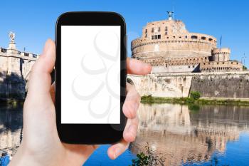travel concept - tourist photographs Holy Angel Castle (Castel Sant Angelo) in Rome city on smartphone with cut out screen with blank place for advertising in Italy