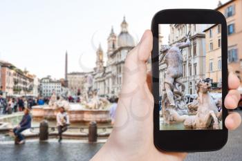 travel concept - tourist photographs sculptures of fountain on piazza Navona in Rome city on smartphone in Italy