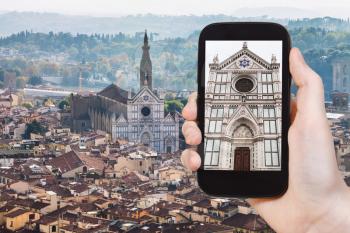 travel concept - tourist photographs Florence skyline with Basilica di Santa Croce on smartphone in Italy