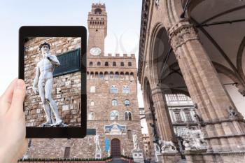 travel concept - tourist photographs David statue near palazzo vecchio in Florence city on tablet in Italy