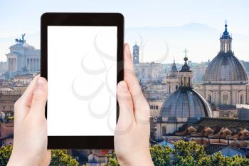 travel concept - tourist photographs skyline of Rome town on tablet with cut out screen with blank place for advertising in Italy