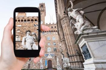 travel concept - tourist photographs David statue in Florence city on smartphone in Italy