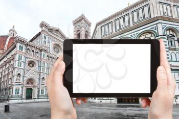 travel concept - tourist photographs baptistery and duomo in Florence city on tablet with cut out screen with blank place for advertising in Italy