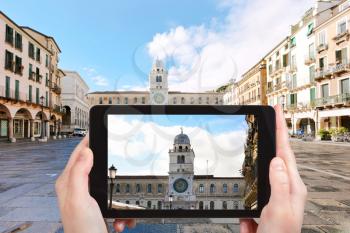 travel concept - tourist photographs palace Capitanio and Camerlenghi on piazza dei Signori in Padua city on tablet in Italy