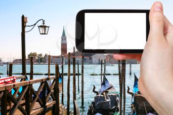 travel concept - tourist photographs gondolas in Venice city on smartphone with cut out screen with blank place for advertising in Italy