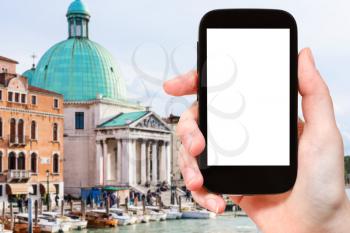 travel concept - tourist photographs Church San Simeone Piccolo in Venice city on smartphone with cut out screen with blank place for advertising in Italy