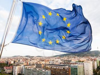 european union flag flutters over houses in Barcelona city