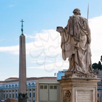 travel to Italy - back side of statue the Apostle Peter and obelisk with cross on Saint Peter's Square (Piazza San Pietro) in Vatican city