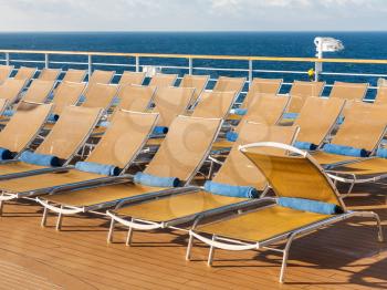 many empty chairs on outdoor deck on stern of cruise liner