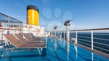 upper deck of cruise liner with empty sunbathing chairs in summer morbning