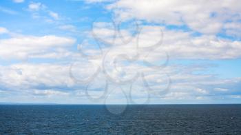 white clouds in blue sky over Baltic Sea in autumn day