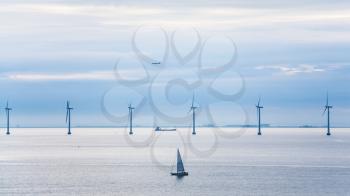 Travel to Denmark - view of yacht, ship, airplane and offshore wind farm Middelgrunden in Oresund near Copenhagen city in Baltic Sea in blue autumn morning