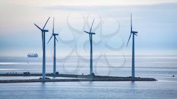 Travel to Denmark - turbines on island of offshore wind farm Middelgrunden in Oresund near Copenhagen city in Baltic Sea in blue autumn morning