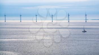 Travel to Denmark - calm surface of Baltic Sea with offshore wind farm Middelgrunden in Oresund near Copenhagen city in blue autumn morning