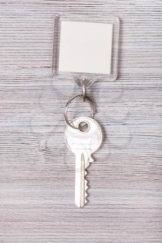 door key with white blank keychain on wood board