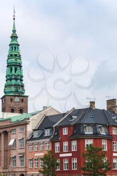 Travel to Denmark - view of Tower of St Nikolaj Church and urban houses in Copenhagen city in autumn day